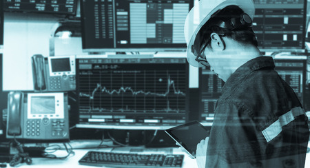 Double exposure of engineer man holding tablet for Stock market quotes and chart in monitor computer...