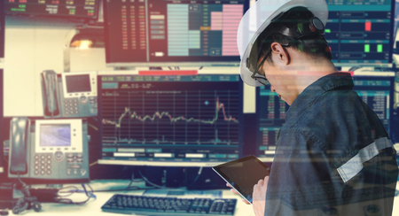 Double exposure of engineer man holding tablet for Stock market quotes and chart in monitor computer...