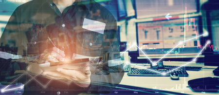 Double exposure of engineer man holding tablet for Stock market quotes and chart in monitor computer...