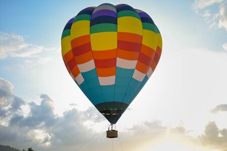 Coroful Hot Air Ballon Flying In The sky with clouds and mountain background.の写真素材