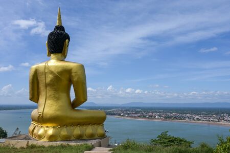 The big golden Buddha statue of Phu Salao temple with Mekong River flows through the Pakse city,Laos.の写真素材