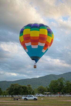 Coroful Hot Air Ballon Flying In The sky with clouds and mountain background.の写真素材