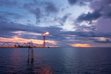 Fire on flare stack at oil and gas central processing platform while burning toxic and release over pressure from process for industry business concept.の写真素材