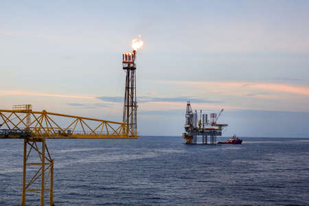 Fire on flare stack at oil and gas central processing platform while burning toxic and release over pressure from process.の写真素材