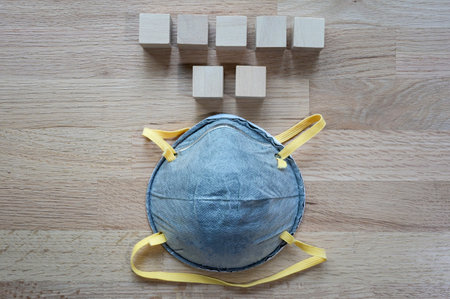N95 mask On the wooden table with group of wooden cube for input wording,Helps prevent infection...
