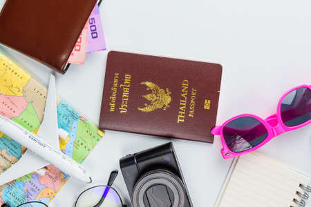 Travel accessories costumes concept for summer vacation trip. Passports, luggage, map, smartphone,sun glasses,camera, note pad, jean on white.の写真素材