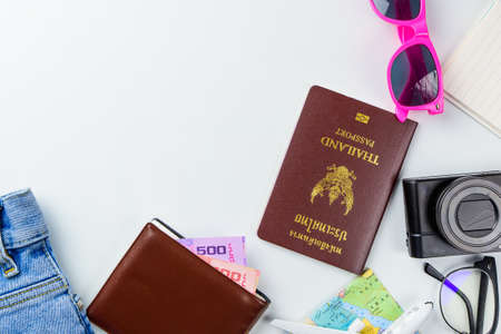 Travel accessories costumes concept for summer vacation trip. Passports, luggage, map, smartphone,sun glasses,camera, note pad, jean on white.の写真素材