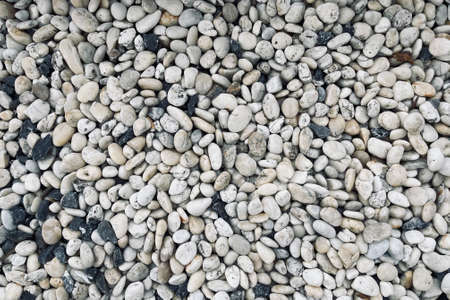 Smooth round pebbles texture background. Pebble sea beach close-up, dark wet pebble and gray dry pebble.の写真素材