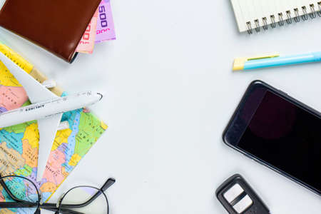 Travel accessories costumes concept for summer vacation trip. Passports, luggage, map, smartphone,sun glasses,camera, note pad, jean on white.の写真素材