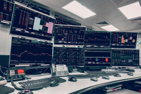 Display of Stock market quotes and chart in monitor computer room with business office equipments .business and money concept, panorama photo.の写真素材