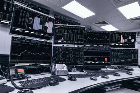 Display of Stock market quotes and chart in monitor computer room with business office equipments .business and money concept, panorama photo.の写真素材