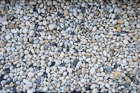 Smooth round pebbles texture background. Pebble sea beach close-up, dark wet pebble and gray dry pebble.の写真素材