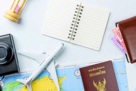 Travel accessories costumes concept for summer vacation trip. Thailand Passports, luggage, map, smartphone,sun glasses,camera, note pad, jean on white.の写真素材