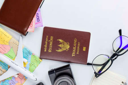 Travel accessories costumes concept for summer vacation trip. Thailand Passports, luggage, map, smartphone,sun glasses,camera, note pad, jean on white.の写真素材