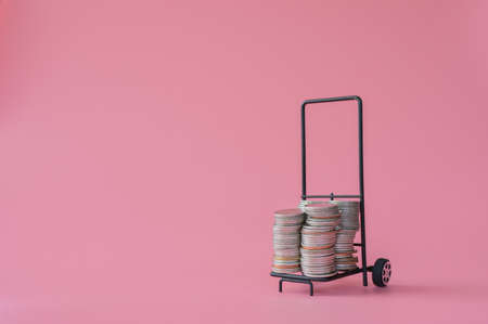 Many coins in the blue shopping cart Isolated on pink background and copy space, saving and investment concept.の写真素材