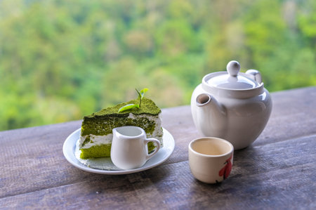 Tea set, Cups and teapot of green tea on wooden board with mountain and forest background.の写真素材
