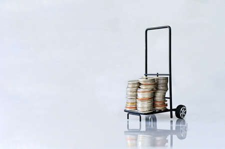 Many coins in the blue shopping cart Isolated on white background and copy space, saving and investment conceptの写真素材