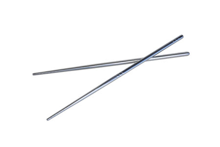 Two shiny silver metal chopsticks are casually crossed and isolated on a clean white background. These stainless steel eating utensils are commonly used for Asian cuisine, represenの写真素材