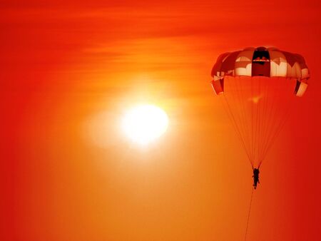 A beautiful background of a parasailing parachute on the backdrop a sunset on an evening sky.の写真素材