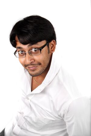 A young Indian guy in a funny pose and expression, on white studio background.の写真素材