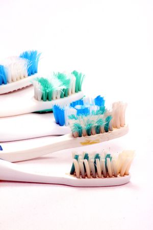 A metaphorical image of a team of old used toothbrushes, on a white fabric.