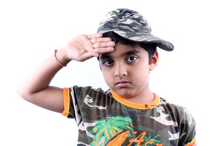 A little Indian boy posing like a soldier, on white studio background.の写真素材