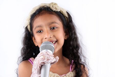 A portrait of a cute Indian girl in a singing performance, on white background.の写真素材