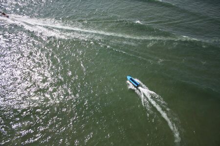 An aerial view of a speedboat in green ocean water.の写真素材