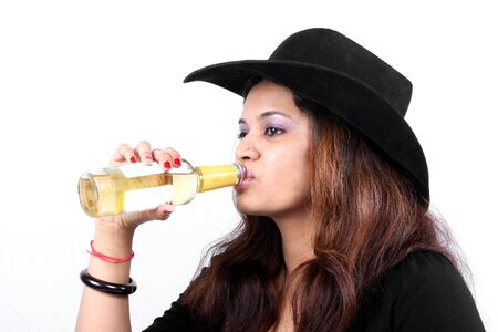 A portrait of an Indian woman wearing a hat, drinking a refreshing drink.の写真素材