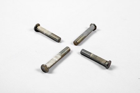 Four bolts of an industrial machine, on a white fabric.の写真素材