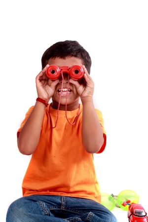 A cute Indian kid looking through red binoculars.の写真素材