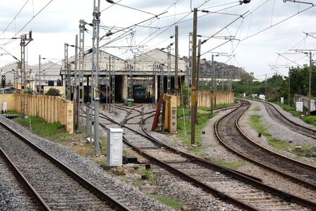Railway tracks leading to a hangar with trains.の写真素材