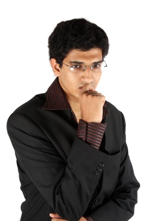 A young Indian businessman in a worried mood, on white studio background.の写真素材