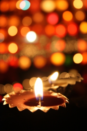 Traditional lamp lit on the blur of colorful lights on the festive occassion of Diwali often known as の写真素材