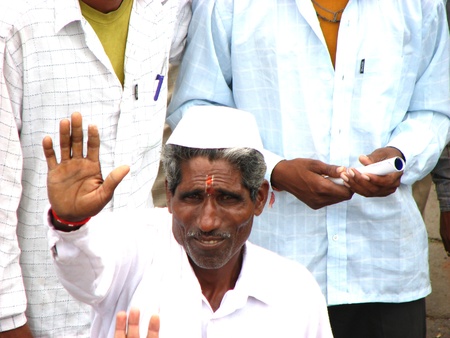 An Indian pilgrim waving his hand through the crowd.