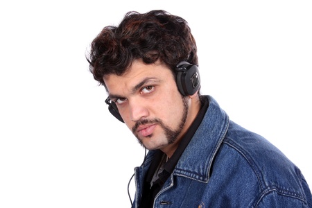 An Indian Guy listening to music on headphones, on white studio background.の写真素材