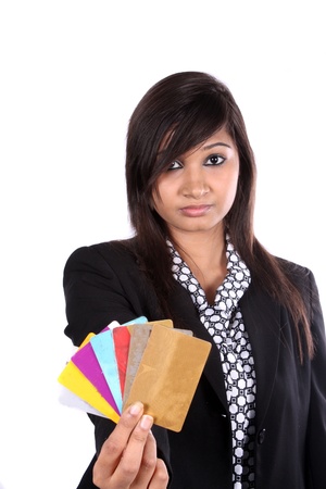 An Indian business executive showing different credit cards, on white studio background.の写真素材