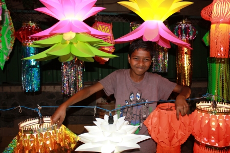 A poor Indian boy displays traditional lanterns in his streetside shop on the occassion of Diwali festival.のeditorial素材