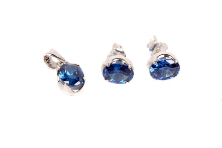 A set of silver jewelery with pendant and earrings made with precious blue gemstones, on white studio background の写真素材