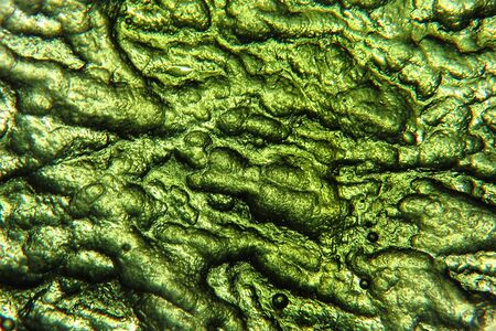 A background with the texture and patterns on a precious Moldavite stone