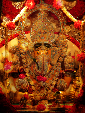 A lord Ganesha idol studded with precious gemstones in a Hindu temple during Ganesh festivalの写真素材