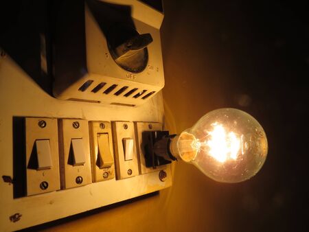 An old switchboard with fan regulator and tungsten bulb.の写真素材