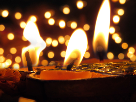 Traditional Lamps lit on the occassion of Diwali festival on the backdrop of blur lightsの写真素材