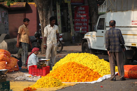 Pune, India - October 21, 2015: A man selling marigold flowers to a customer on the streetside in India, on the eve of Dassera festivalのeditorial素材