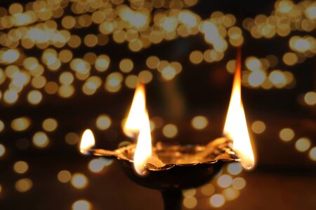 A holy ritual lamp lit in temple on the occasion of Diwali festival in India, on the backdrop of...