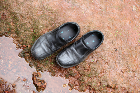 Black leather shoes abandoned on a rock in a camping trialの写真素材