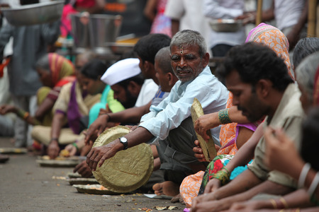 Pune, India - July 11, 2015: Hungry pilgrims called warkaris wait to be served on the streets during the famous wari pilgrimmage in India.のeditorial素材