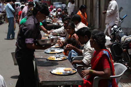Pune, India - July 11, 2015: Indian pilgrims known as warkaris been served free meal on the side of the road during Wari festival in India.のeditorial素材
