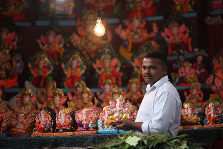 Pune, India - September 16, 2015: A man selling Lord Ganesh idols on the eve of Ganesh festival in India. The festival involves thousands of visitors from all over the world every year, in the main celebration city - Pune.のeditorial素材