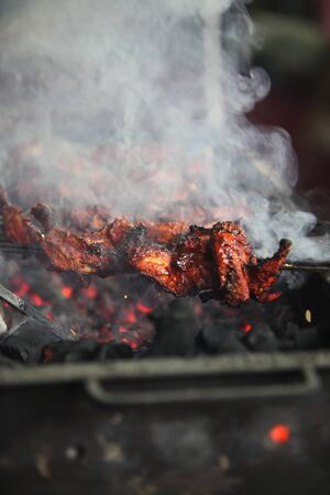 Delicious smoked tandoori chicken being prepared on a grill in an Indian hotel.